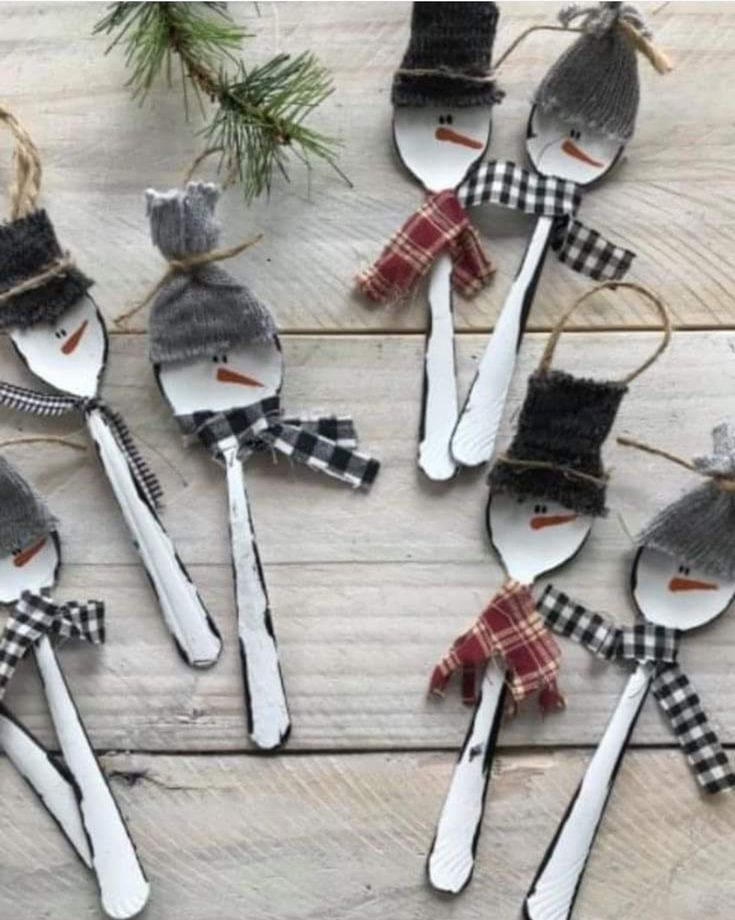 spoons are decorated to look like snowmen with hats and scarfs on them