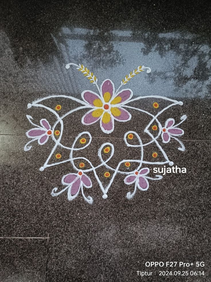 a close up of a sidewalk with flowers painted on it and the words sullatha written in white