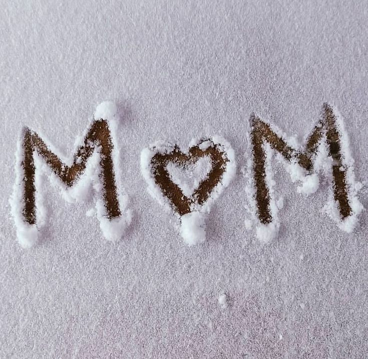 the word mom written in snow with a heart