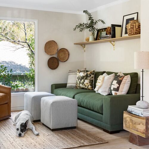 a living room filled with furniture and a dog laying on the floor next to it