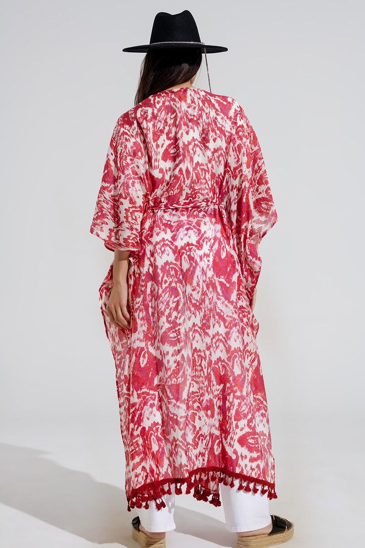 Introducing our enchanting Red Long Kimono with Drawstring Closing in Tribal Print, a must-have piece for your summer wardrobe. This maxi-length kimono features a captivating tribal print that adds a touch of bohemian flair to any ensemble.  Crafted from a lightweight chiffon fabric blend of 70% viscose and 30% polyamide, this kimono is perfect for layering over your favorite swimsuit as a stylish beach cover-up. The 3/4 length sleeves and relaxed fit ensure comfort and ease of movement, while the drawstring closing adds a customizable touch to your look.  Complete with fringe trim details at the bottom, this kimono exudes casual elegance with a hint of boho-chic charm. Whether you're lounging by the pool or strolling along the beach, this kimono is sure to keep you looking effortlessly st Tan Scarf, Long Kimono, Scarf Headband, Fringe Trim, Estilo Boho, Romper Pants, Trim Detail, Casual Elegance, Chiffon Fabric