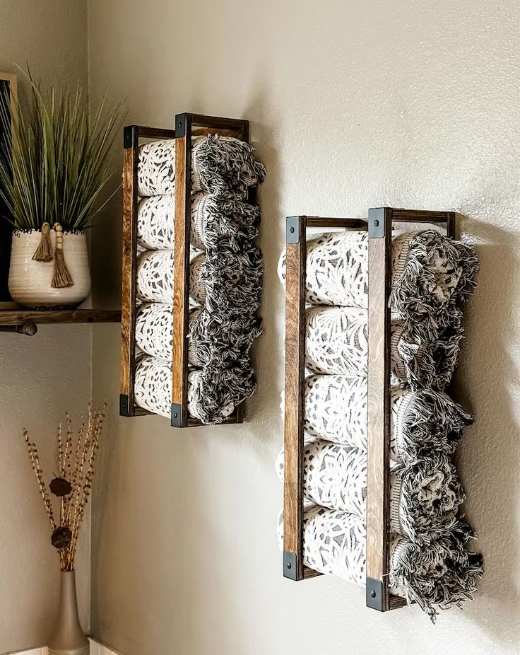 two wooden crates with doily on them are hanging from the wall next to a potted plant