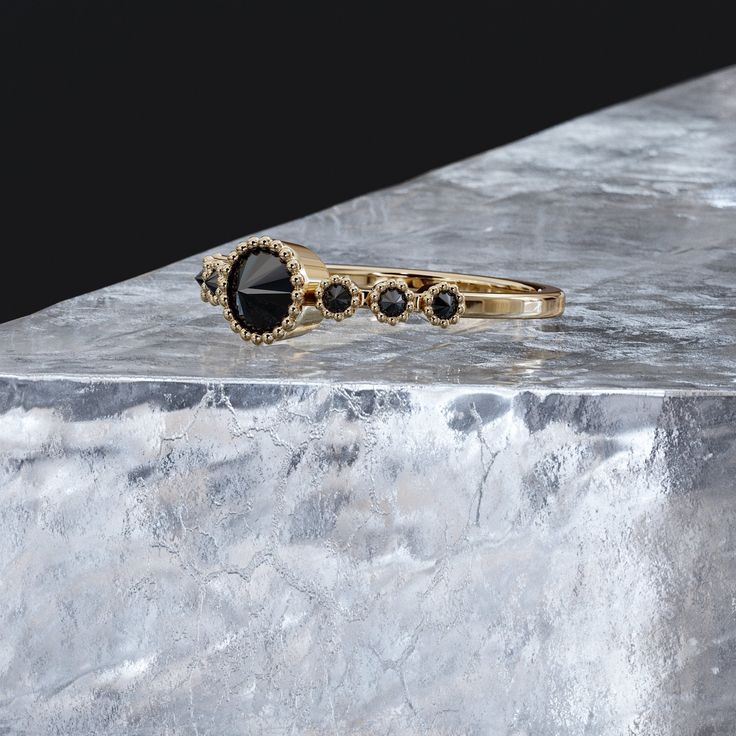 two black and gold rings sitting on top of a marble block