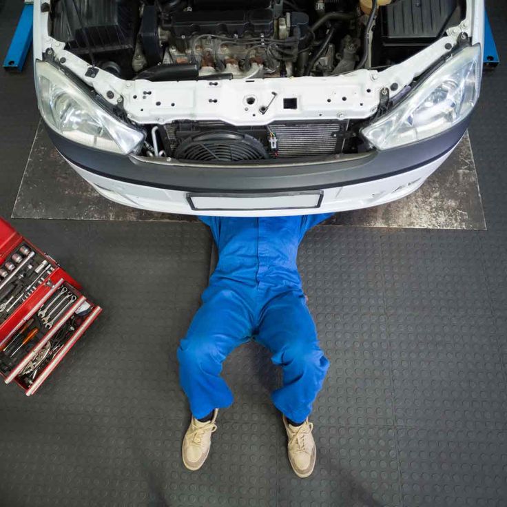 a mechanic working on the hood of a car