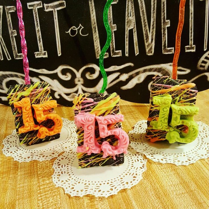 three small birthday candles are sitting on doily with the number five in front of them