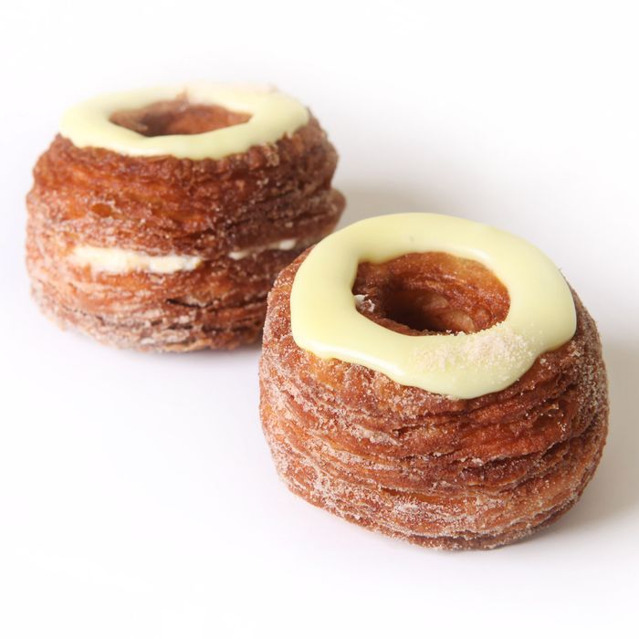 two donuts with white frosting on them sitting next to each other in front of a white background