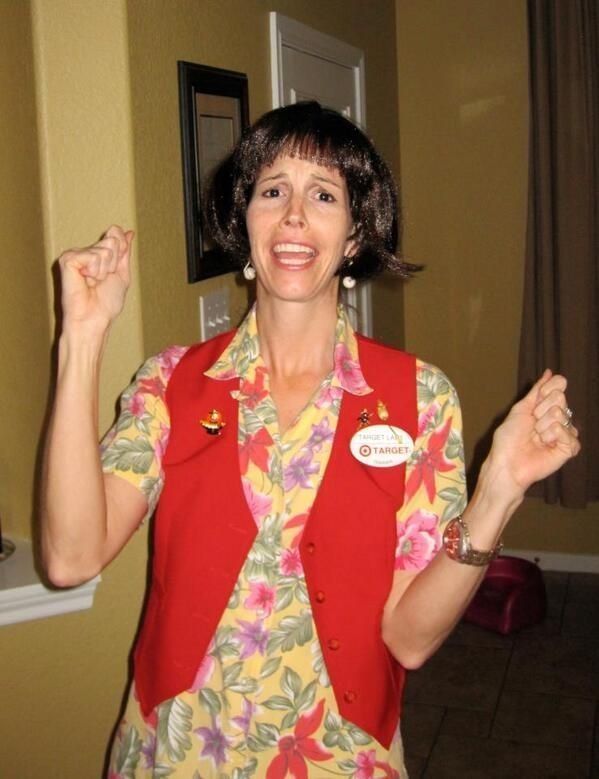 a woman wearing a red vest and flowered shirt is holding her fist up in the air