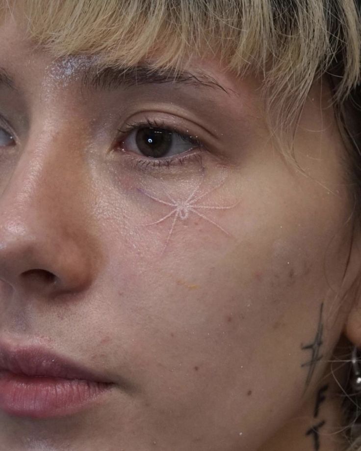 a close up of a person with piercings on her face and nose, looking at the camera