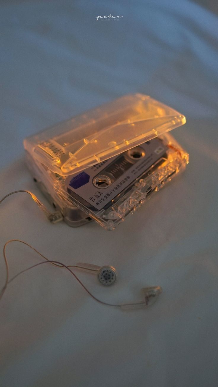 an old cassette player is laying on its side with ear buds attached to the case