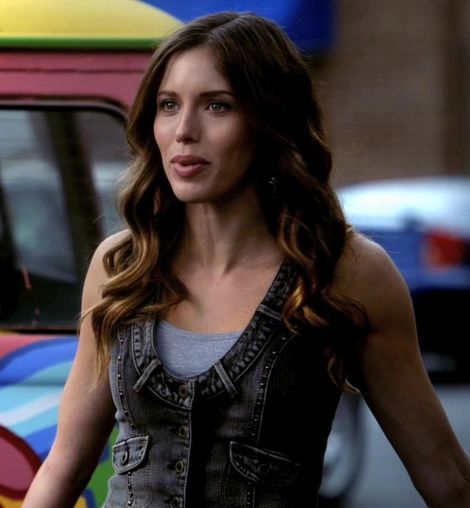 a beautiful young woman standing next to a colorful truck