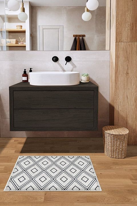 a bathroom with a sink, mirror and rug