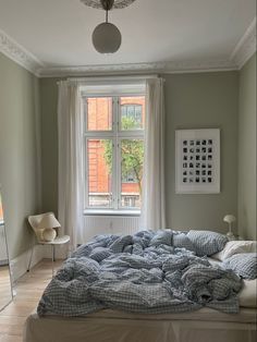 a bed sitting under a window in a bedroom