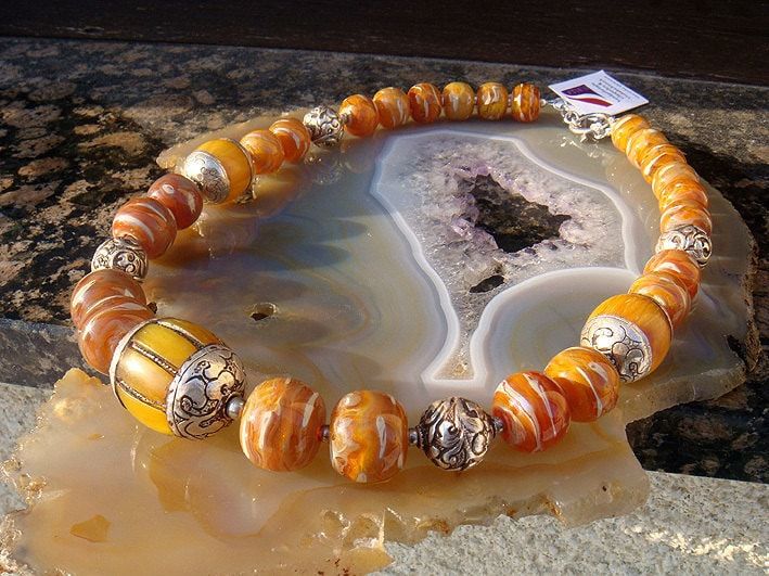 This wonderful, precious necklace was made with hand-crafted lampworked borosilicate glassbeads in stunning shades of amber and silvered cream which is shimmering in light reflections of deep purple. The beads are combined with hand-crafted, bordered amber beads and tibetan beads made of fine silver. It's closed with a solid sterling silver toggle clasp. HANDCRAFTED ONE OF A KIND JEWELRY! colors i used: amber, beige, silver bead sizes: the amber bead in the middle is about 30 x 23 mm - the diame Handmade Yellow Baltic Amber Necklaces, Handmade Baltic Amber Necklace In Yellow, Unique Round Bead Glass Jewelry, Unique Glass Jewelry With Round Beads, Handmade Yellow Baltic Amber Necklace, Unique Jewelry With Round Glass Beads, Amber Jewelry With Large Beads For Gifts, Unique Murano Glass Necklaces With Large Beads, Unique Murano Glass Beaded Necklaces