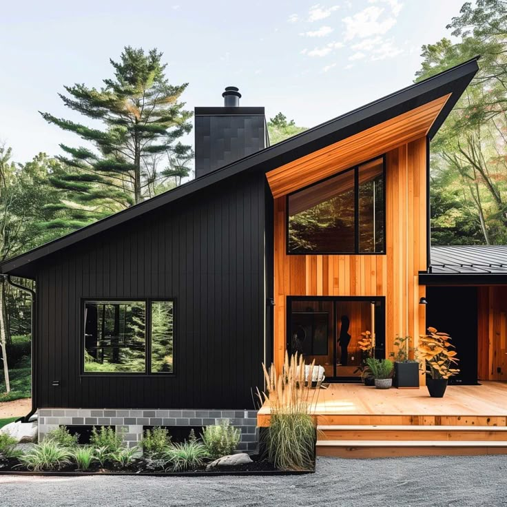 a modern house in the woods with large windows and wooden steps leading up to it