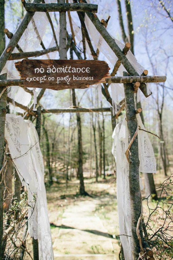 a wooden sign that says no admittance except for gravity business hanging on a tree in the woods