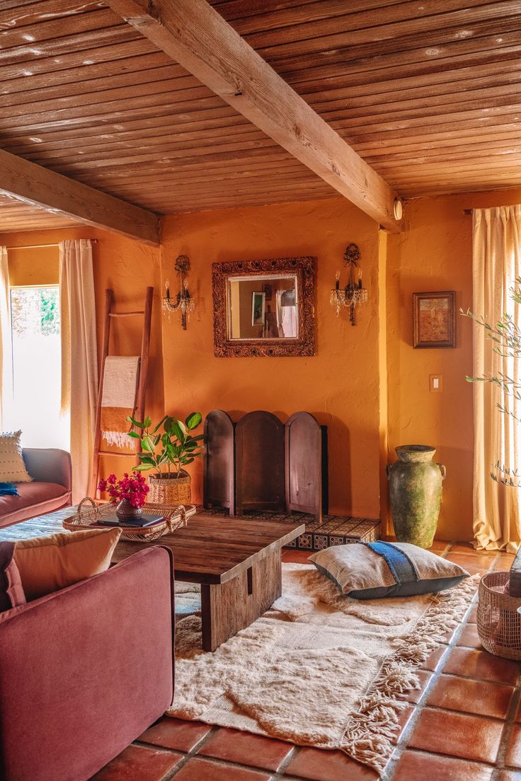 a living room with orange walls and furniture