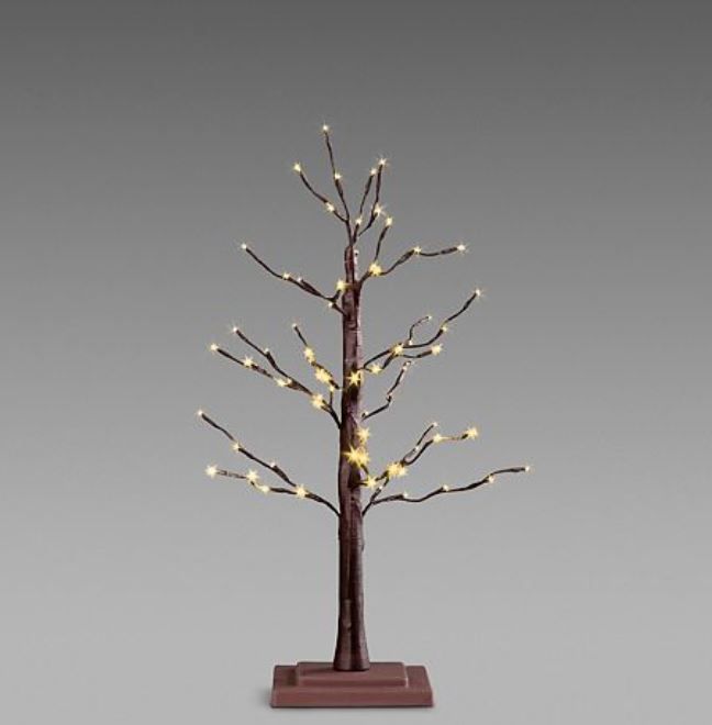 a lighted tree with white lights on it's branches and brown base, in front of a gray background