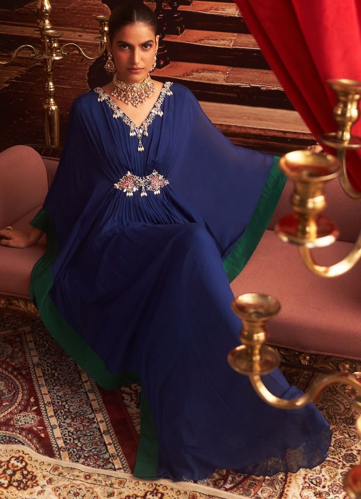 Make a statement at your next Sangeet or cocktail party in this stunning Electric Blue Chiffon Kaftan. With its exquisite embroidery along the neckline and sleeves, this Indo-Western draped kaftan offers the perfect blend of comfort and style for wedding guests. The flowing chiffon fabric drapes beautifully, creating a luxurious silhouette that's ideal for festive occasions. Whether it's a Sangeet or a cocktail event, this kaftan ensures you exude elegance. Composition : Kaftan - Chiffon & Lining - Satin Care: Dry Clean Only and Vacuum Storage This product can be customized for sleeves, blouse length and neckline Delivery : 2-4 weeks as the product is hand crafted. Check Size Guide or choose MySize for free customisation (All Sizes above XL can be made at 15% additional cost) For more info Draped Kaftan, Chiffon Kaftan, Style For Wedding, Vacuum Storage, Embroidered Chiffon, Indian Wedding Wear, Sleeves Blouse, Cocktail Event, Draped Fabric