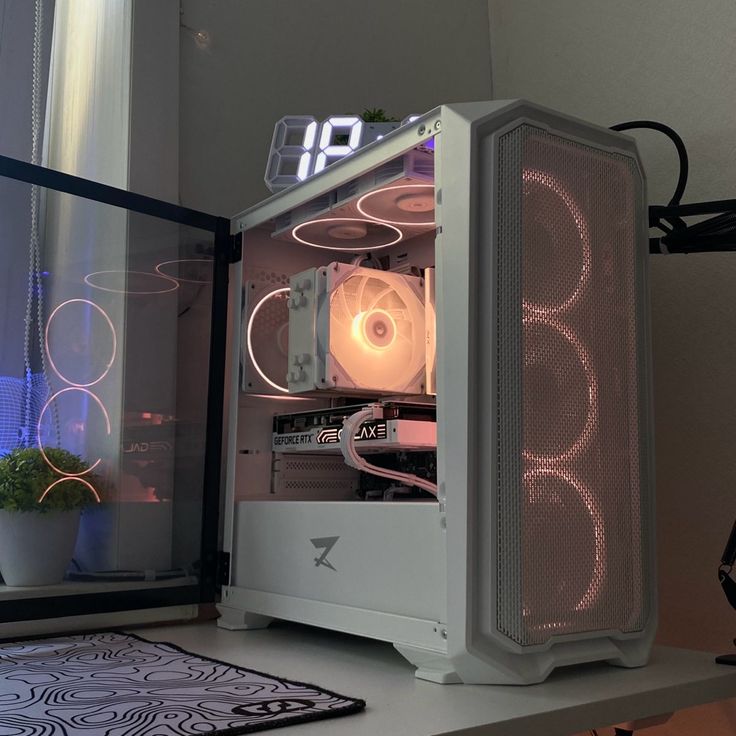 a white computer case sitting on top of a desk next to a plant and window