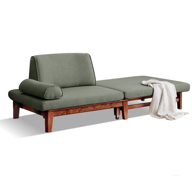 a green couch sitting on top of a wooden frame next to a white blanket and pillow