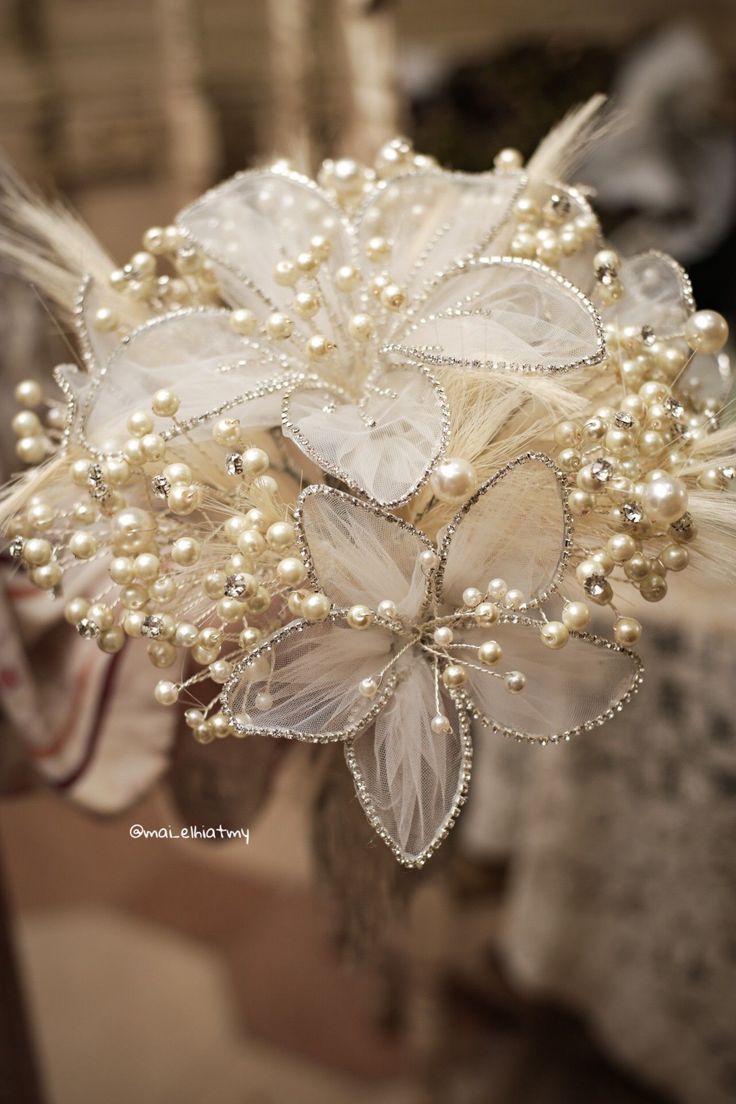 a bridal bouquet with pearls and feathers