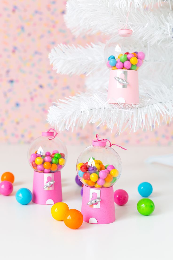 candy dispensers in front of a white christmas tree with sprinkles