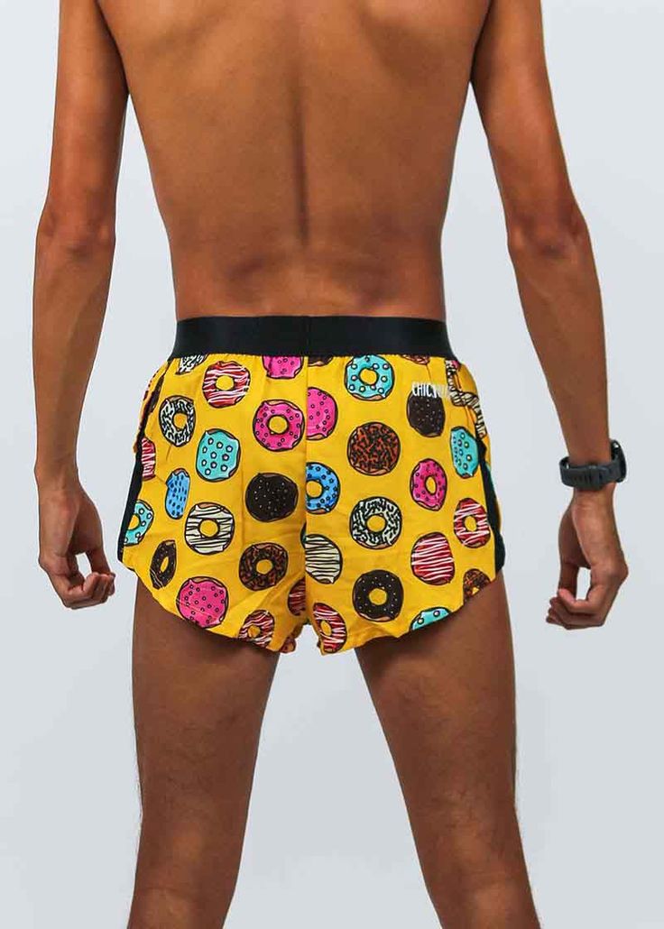 a man in yellow shorts with donuts printed on the side and black belt around his waist