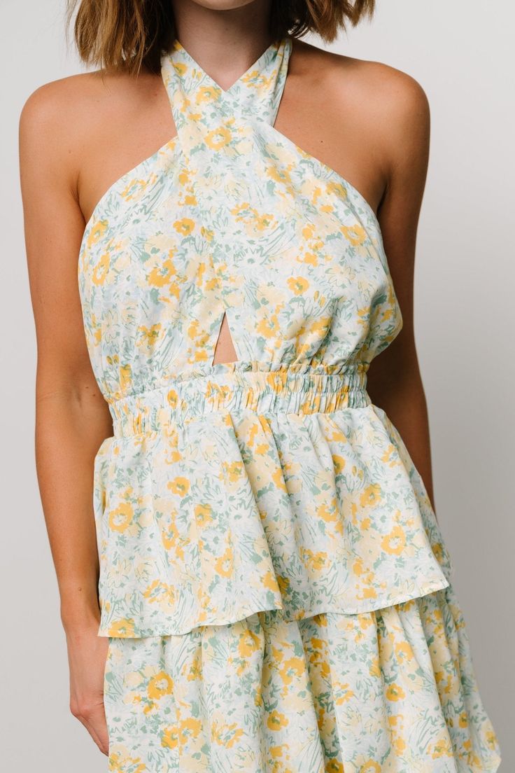 FINAL SALE A perfect piece for those fun-in-the-sun moments and memories Off white with yellow, blue, and green floral print Chiffon material has no stretch Halter neck with self-tie Open back style Elastic waistband Tiered skirt is lined until bottom tier Self and Lining: 100% Polyester Marianne is 5'6, cup size 34D, size 6 and wearing size S Yellow Dresses For Spring Summer Outings, Ditsy Floral Print Sundress For Summer Daytime, Summer Sundress With Ditsy Floral Print For Brunch, Yellow Ditsy Floral Print Mini Dress For Spring, Spring Mini Dress With Lemon Print For Brunch, Yellow Mini Floral Dress For Summer, Yellow Ditsy Floral Mini Dress For Spring, Yellow Mini Dress With Ditsy Floral Print For Spring, Summer Halter Neck Sundress For Daytime