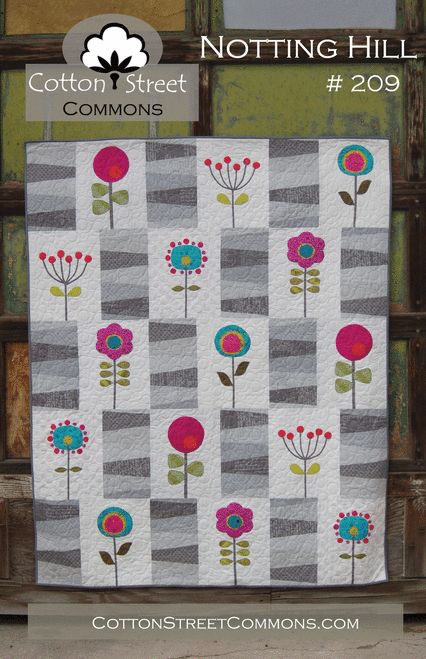 a quilted wall hanging with flowers on it