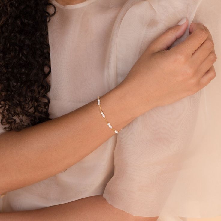 Our elegant and delicate Hali Pearl Station Bracelet is the ultimate accent to your bridal look. Give this minimalist charm bracelet as a gift to your bridesmaids or gift to yourself on the big day. Material: High Quality Solid 925 Sterling Silver Finish: Sterling Silver ∙ 18K Gold Featuring ~3-5mm Pearl Charms on a minimalist chain, adjustable 6 to 8 inches Part of the Casablanca Collection SKU: RR-BR038 Elegant Simple Bangle Jewelry, White Feminine Bracelets For Wedding, Dainty Diamond Bracelet With Delicate Chain For Gift, Delicate Diamond Bracelet As Gift, Classic Pearl Bracelet For Bridesmaid Gift, Elegant Wedding Chain Bracelet, Elegant Simple Design Jewelry For Formal Occasions, Sterling Silver Chain Bracelet For Wedding, Delicate Chain Bracelet For Anniversary