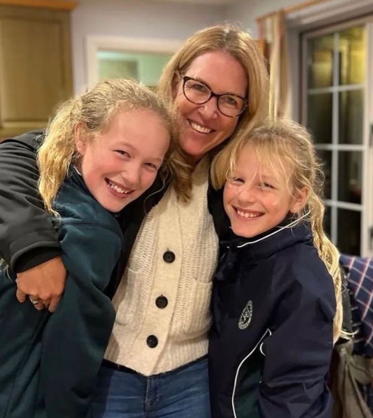 a woman and two children are smiling for the camera