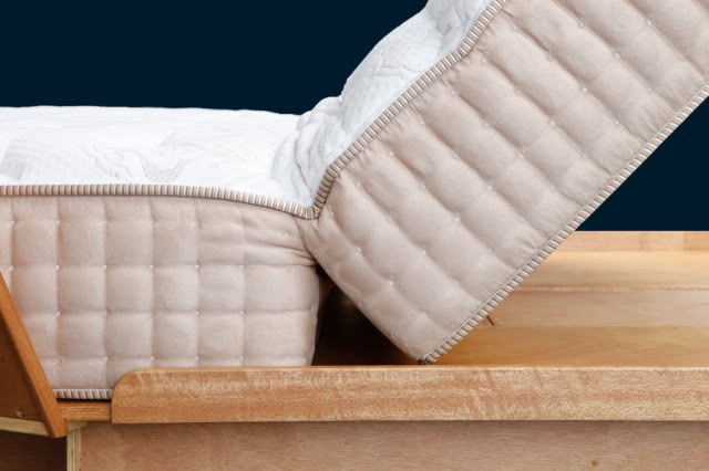 a mattress sitting on top of a wooden bed frame