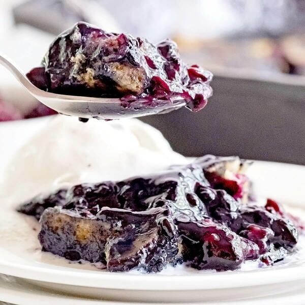 a spoonful of blueberry cobbler on a white plate