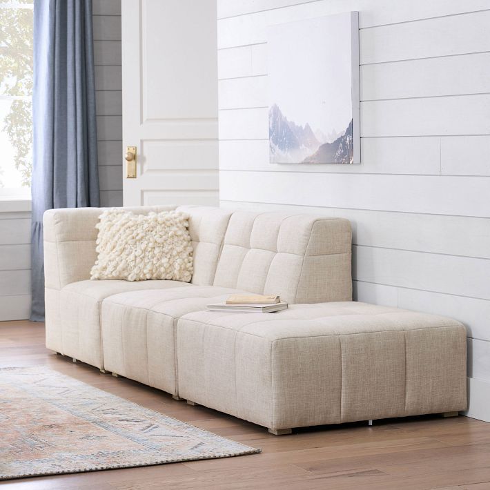 a living room with a white couch and rugs on the wooden floor next to a window