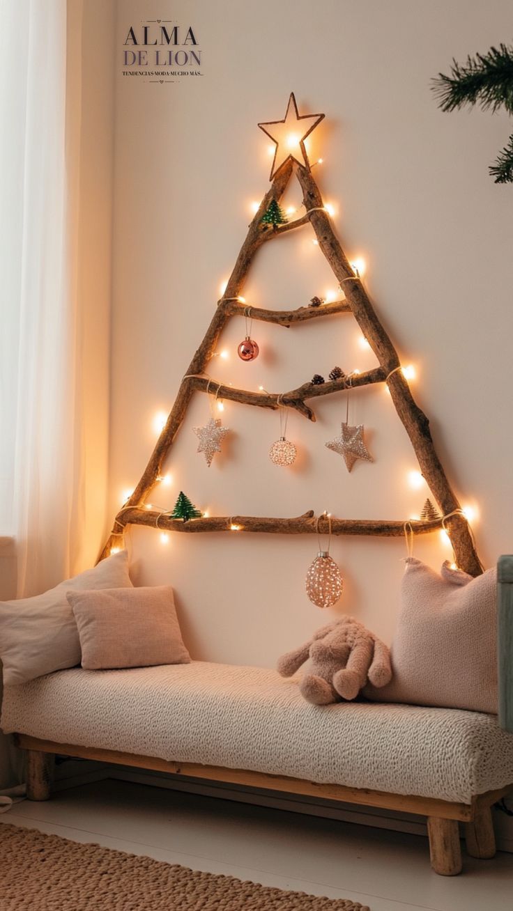 a christmas tree made out of branches with lights on it and a teddy bear sitting in the foreground