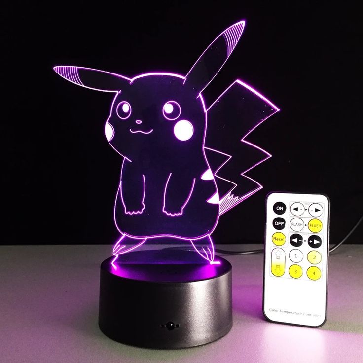 a pikachu lamp next to a remote control