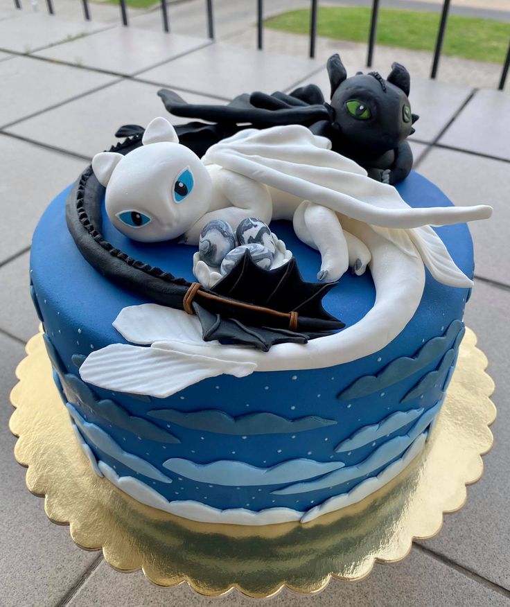 a blue cake with white frosting and black decorations