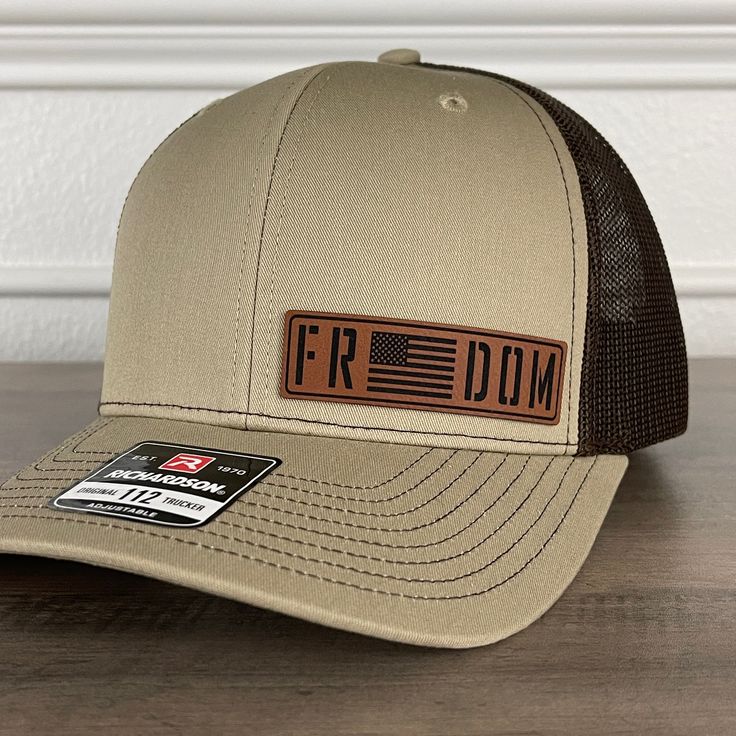 Freedom American Flag Patriotic Leather Patch Hat Khaki/Brown. Specifications: 🧢 Richardson original 112 trucker; adjustable for the perfect fit 🎩 60/40 cotton/polyester blend for comfort 📏 One size fits most 🏷️ Expertly laser engraved leatherette patch design 📦 Ships in 2 to 3 business days from our Orlando Studio Care Instructions: 🚫 Do not wash; spot clean only Please Note: 🌈 Colors may vary from photos based on your viewing screen.