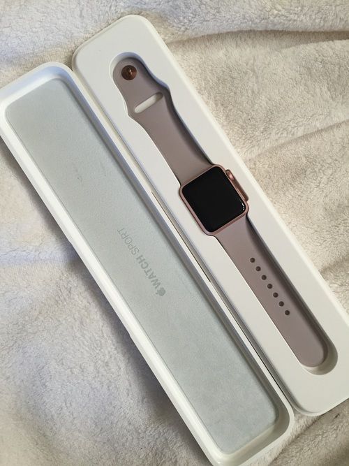 an apple watch sitting in its box on a white bed sheet with the cover pulled down