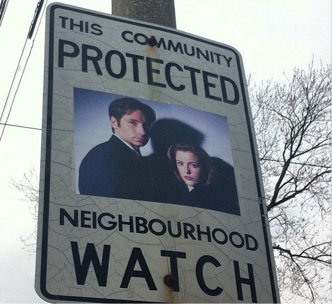 a sign on a pole that says, this community protected neighborhood watch with an image of two people