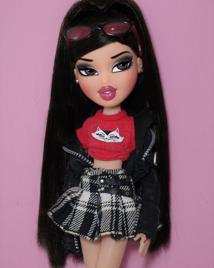 a close up of a doll wearing a skirt and jacket with sunglasses on her head