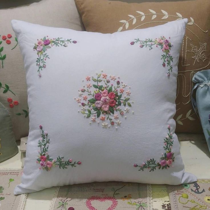 a white pillow with pink flowers on it