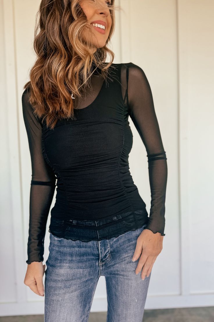 The Little Number Mesh Mock Neck Top is a must-have for any fashion-forward individual! This versatile piece features stretchy mesh fabric, long sleeves, and ruffle hems for a touch of feminine flair. Layer it over a tank or bralette for an effortlessly stylish look. Fits true to size. Model is 5’10”, 34D, a dress size 4 and wearing a small. 93% Nylon, 7% spandex Fitted Tops With Sheer Sleeves For Winter, Winter Stretch Mesh Top With Long Sleeves, Winter Long Sleeve Stretch Mesh Top, Sheer Nylon Tops For Fall, Stretch Mesh Top With Ruched Detail, Stretch Ruched Mesh Top, Sheer Stretch Mesh Top For Winter, Stretch Mesh Top With Sheer Sleeves For Winter, Fitted Sheer Long Sleeve Top For Layering