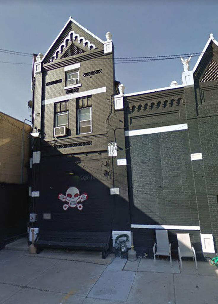 a building with a skull and crossbones painted on it's side next to other buildings