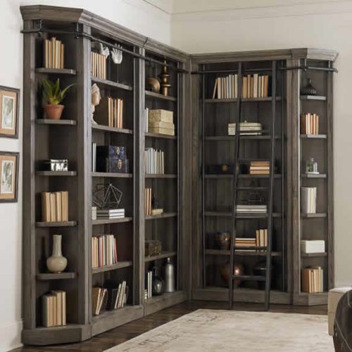 a living room filled with lots of bookshelves next to a couch and chair