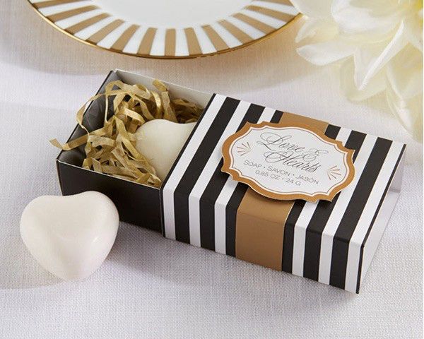 a black and white striped box with soap in it next to a flower on a table