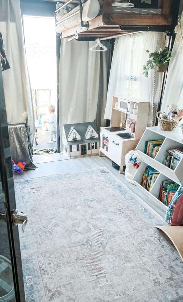 a living room filled with lots of furniture and bookshelves next to a window