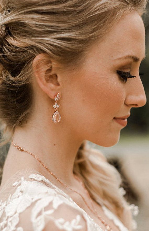 a woman in a wedding dress wearing earrings