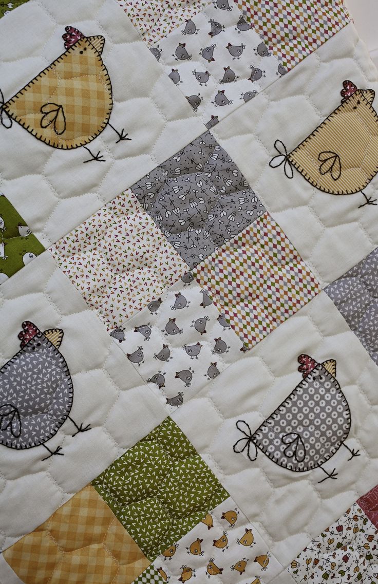 a close up of a patchwork quilt with chickens on it