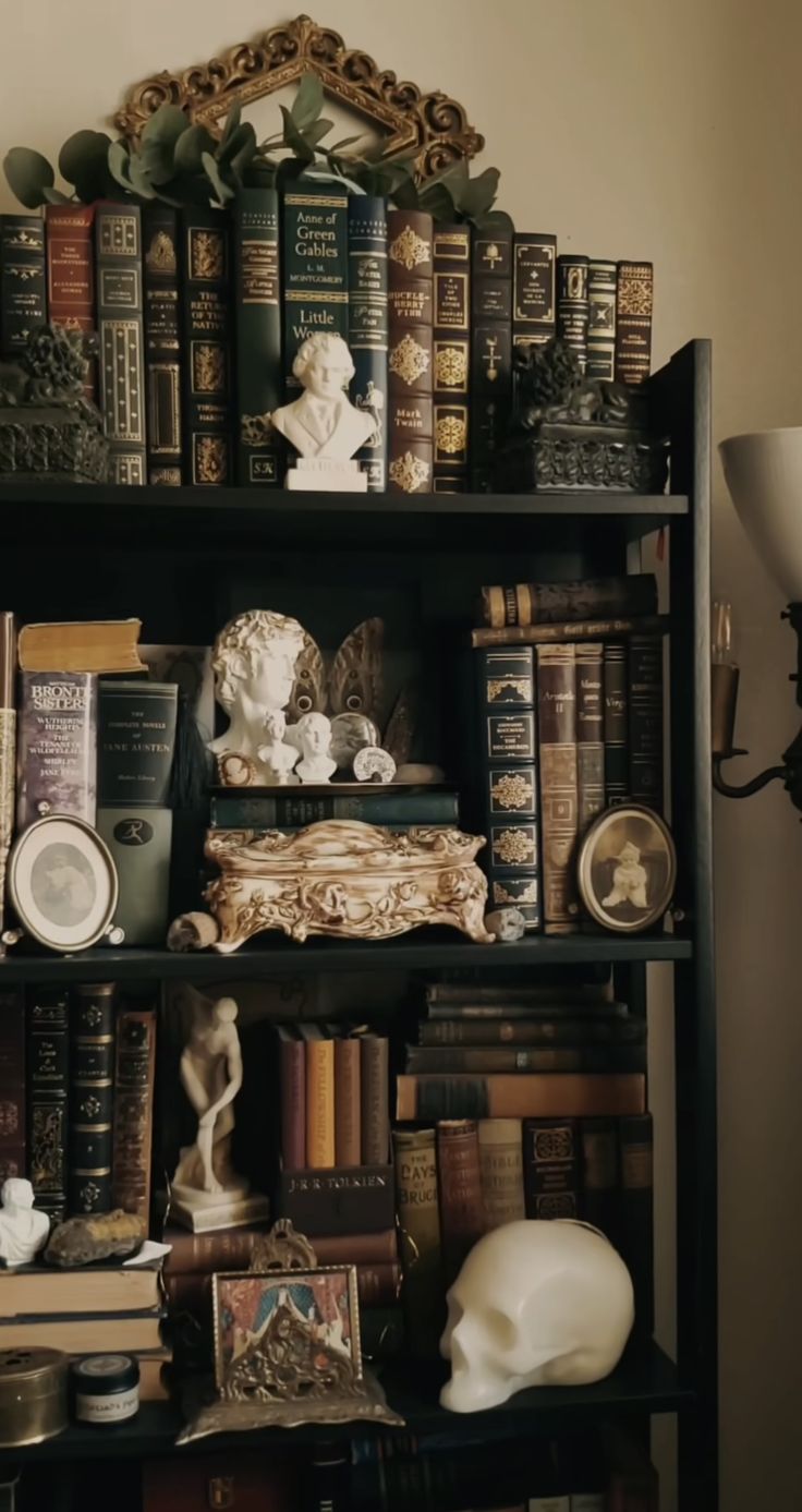 a bookshelf filled with lots of books and figurines on top of it